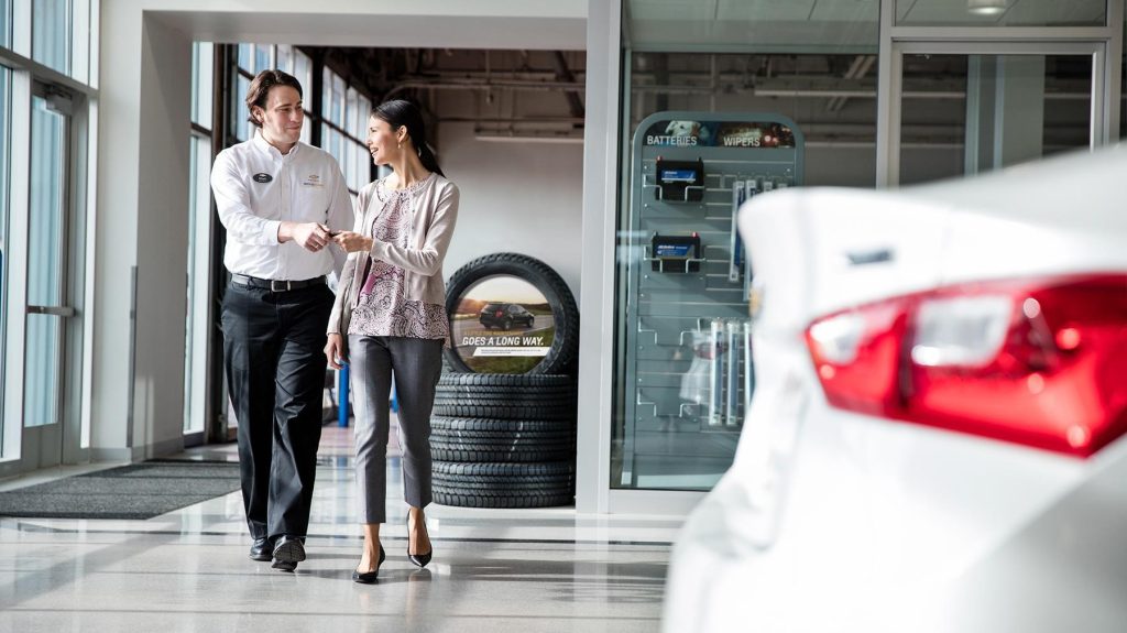 Customer receiving assistance from a service advisor inside a Chevrolet dealership showroom