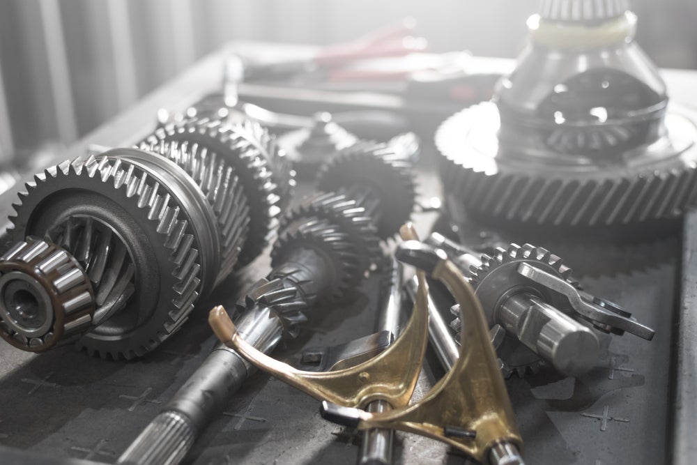Automotive transmission gears and mechanical parts arranged on a workbench.